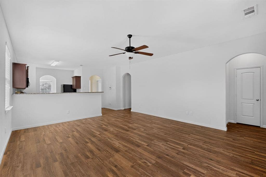 215 Magnolia Drive, Princeton, TX 75407 Open-concept living area with wood-finish flooring, a ceiling fan, and arched doorways