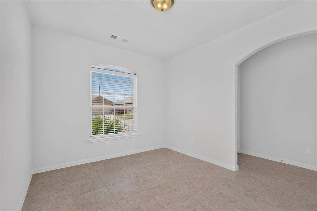 215 Magnolia Drive, Princeton, TX 75407 Arched entryway, tiled flooring, arched window with horizontal blinds, and a flush mount ceiling light
