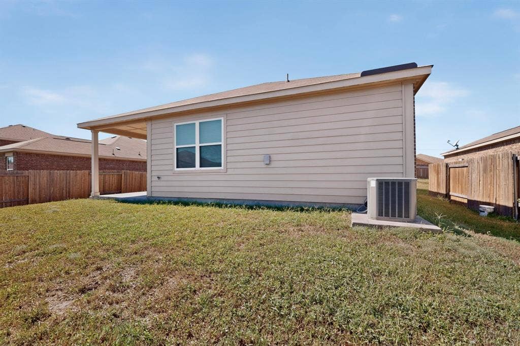 215 Magnolia Drive, Princeton, TX 75407 Backyard featuring an extended covered patio, perimeter fencing, a window with white trim, and vinyl siding