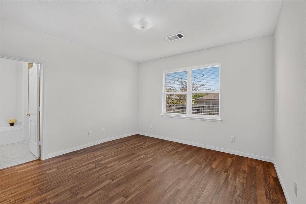 215 Magnolia Drive, Princeton, TX 75407 Wood-finish flooring, white walls, and a window with blinds