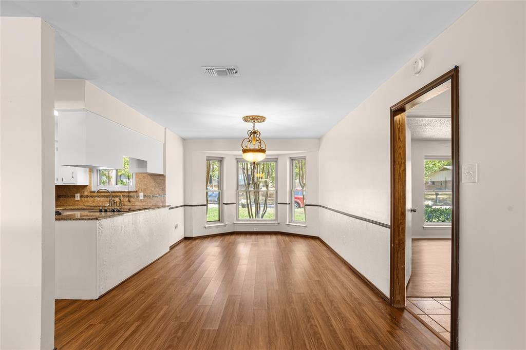 2004 Ford Street, Arlington, TX 76013 Wood-finish flooring, bay window, built-in lighting fixture, kitchen pass-through, and white cabinetry