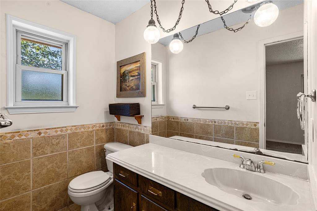 2004 Ford Street, Arlington, TX 76013 White vanity countertop with an integrated sink, polished chrome faucet, and dark wood-finish cabinetry