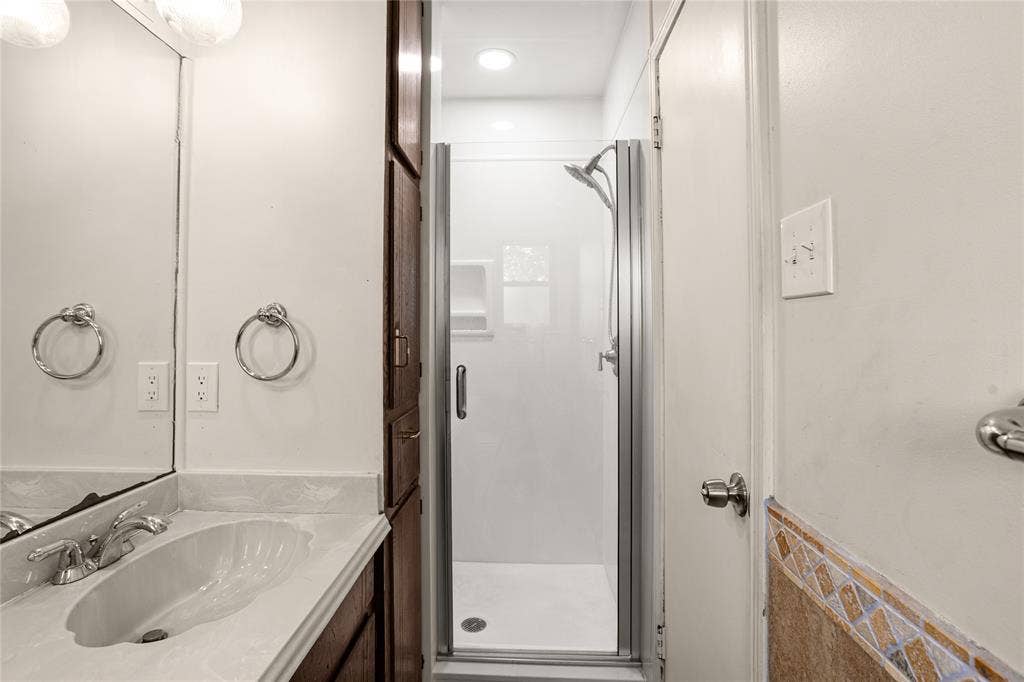 2004 Ford Street, Arlington, TX 76013 Vanity with integrated sink and chrome faucet, accompanied by a built-in wood-finish cabinet