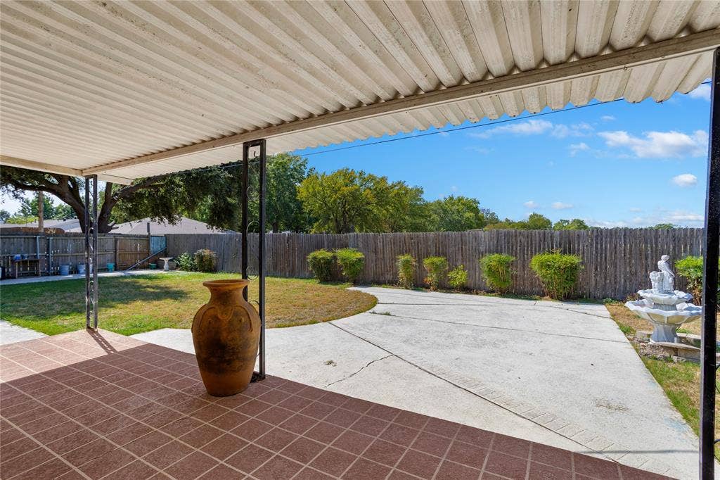2004 Ford Street, Arlington, TX 76013 Covered patio with square terracotta-toned tile flooring, supported by dark metal posts