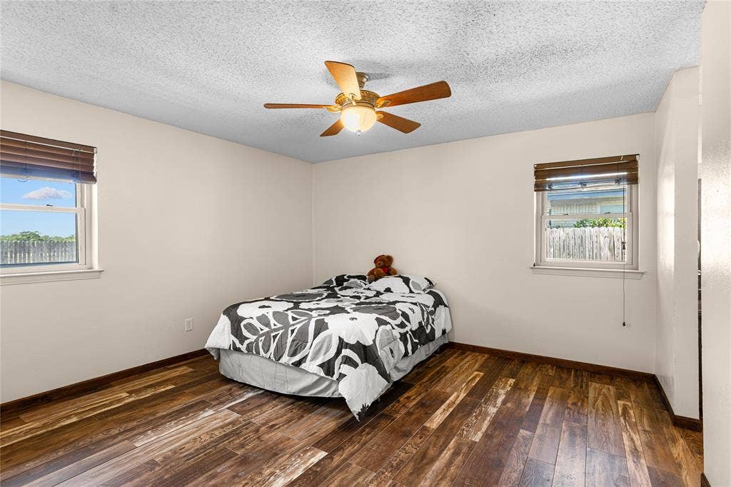 2004 Ford Street, Arlington, TX 76013 Wood-finish flooring, two windows with blinds, ceiling fan with integrated lighting, and neutral wall paint