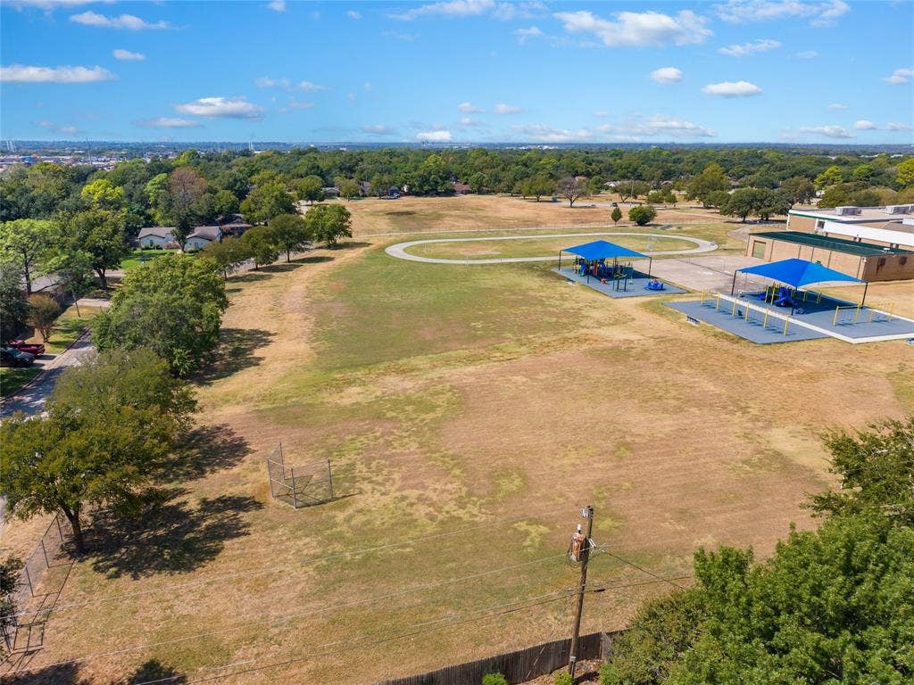 2004 Ford Street, Arlington, TX 76013 Expansive grounds featuring a running track, two shaded play structures, and surrounding mature trees