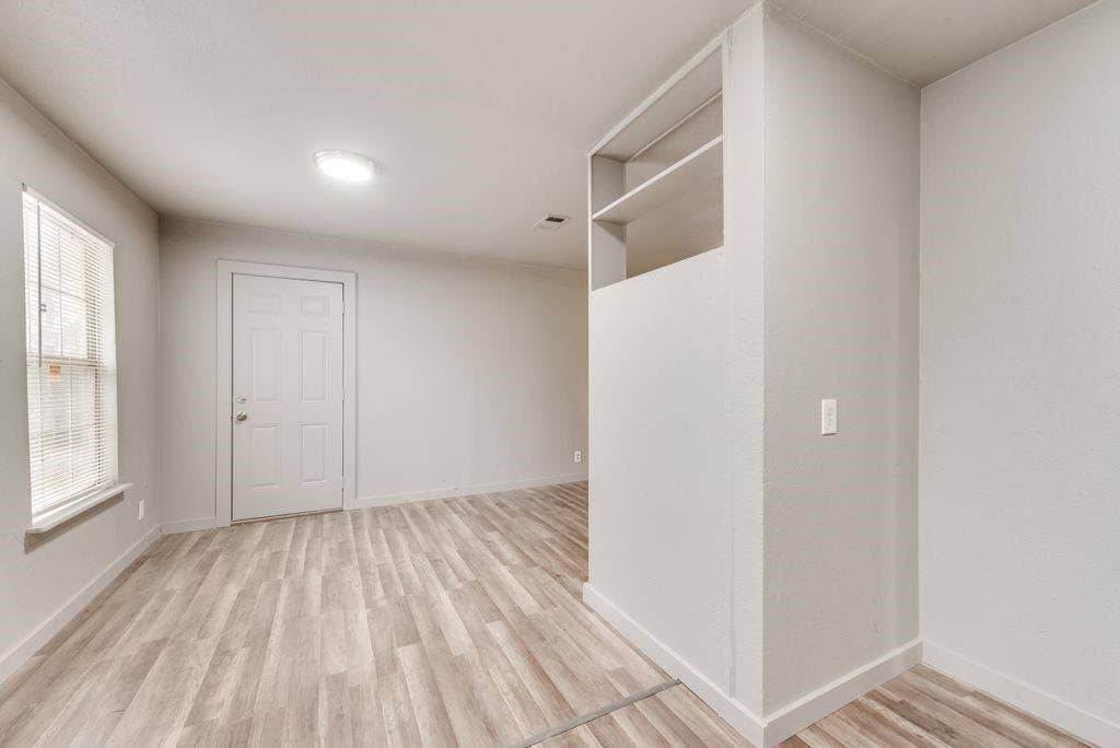 4414 Cinda Ree Lane, Dallas, TX 75216 Wood-finish flooring, built-in shelving, white paneled door, and a flush-mount ceiling light