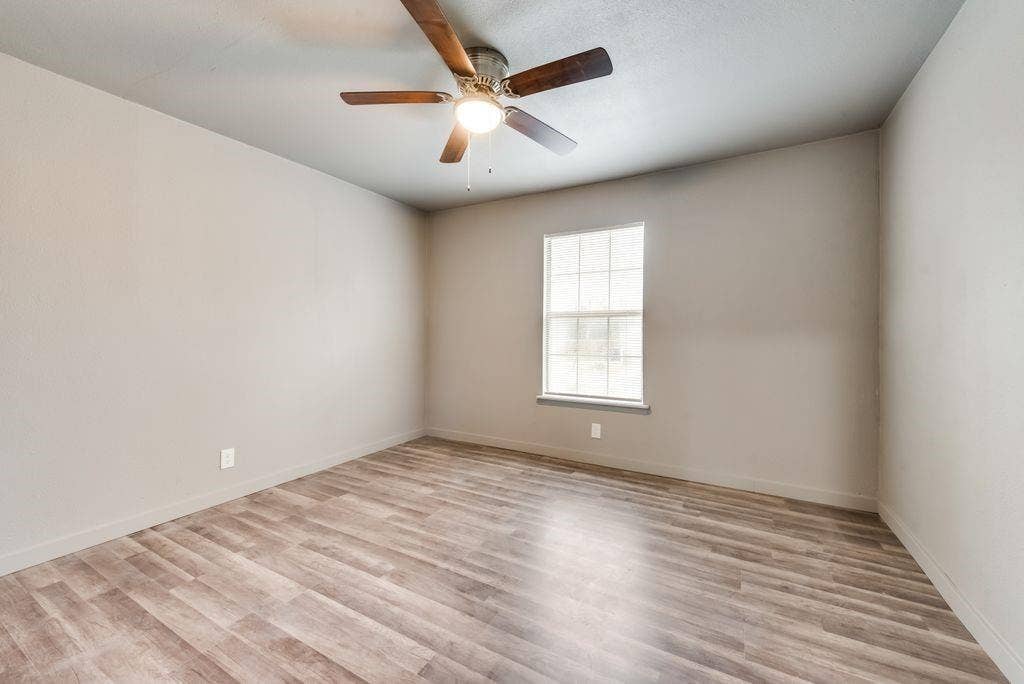 4414 Cinda Ree Lane, Dallas, TX 75216 Neutral wall color, wood-finish flooring, ceiling fan, and a single window