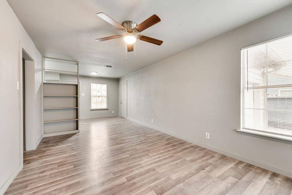 4414 Cinda Ree Lane, Dallas, TX 75216 Wood-finish flooring, built-in shelving, ceiling fan with integrated lighting, and multiple windows