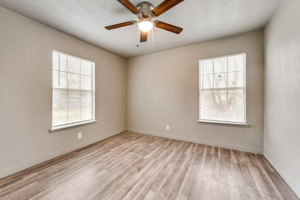 4414 Cinda Ree Lane, Dallas, TX 75216 Wood-finish flooring, two windows, and a ceiling fan with integrated lighting