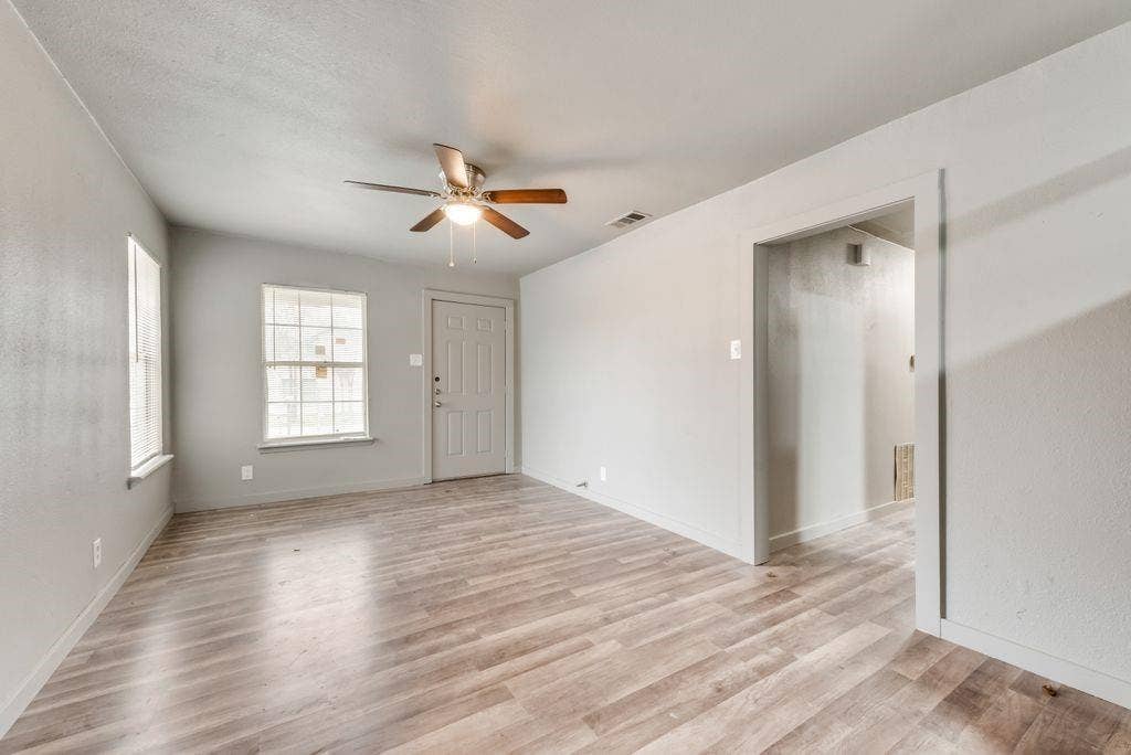 4414 Cinda Ree Lane, Dallas, TX 75216 Wood-finish flooring throughout, light gray wall paint, and a ceiling fan with integrated lighting