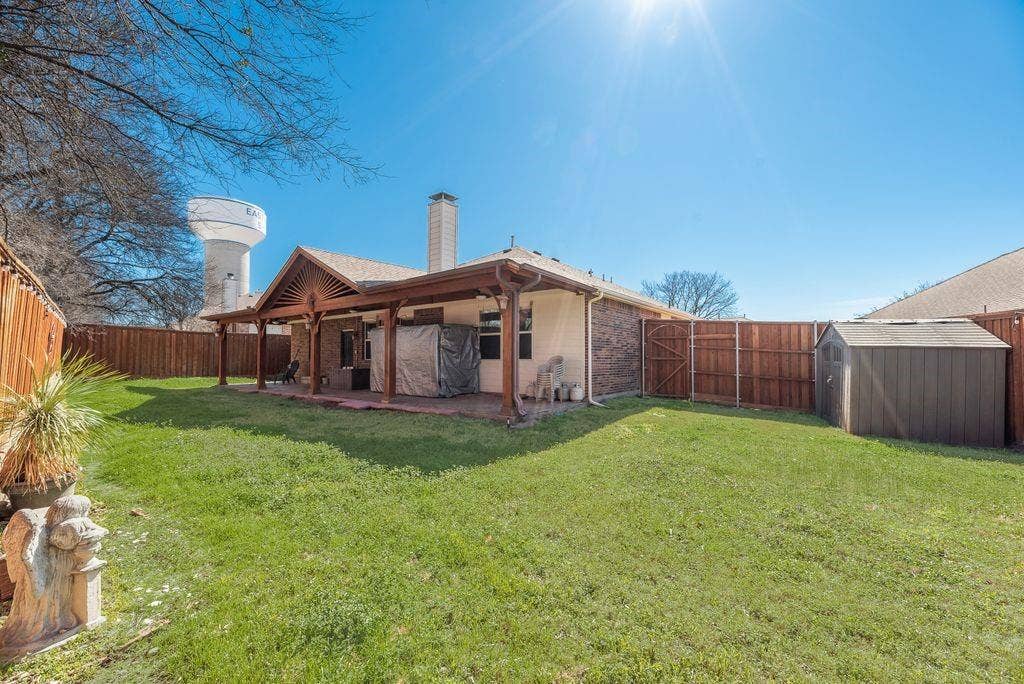 1323 Canyon Creek Road, Wylie, TX 75098 Expansive backyard with a covered patio, wood pergola, and a storage shed