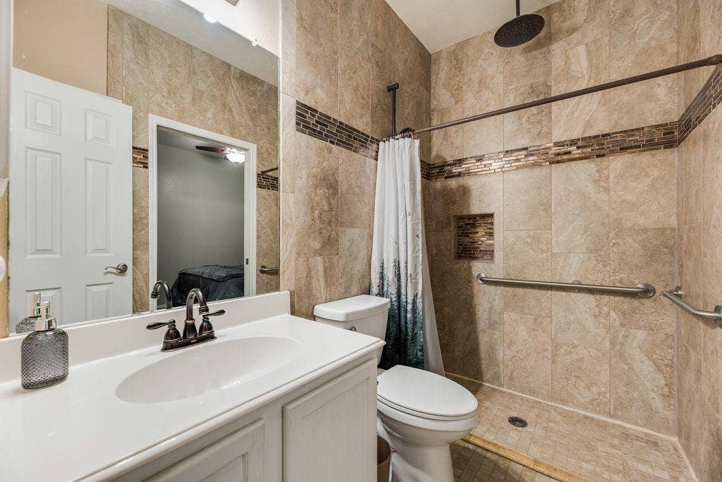 1323 Canyon Creek Road, Wylie, TX 75098 Tiled shower with mosaic accent, built-in niche, and dark bronze rainfall showerhead