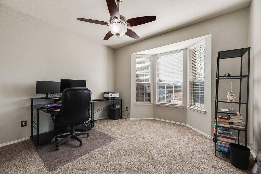 1323 Canyon Creek Road, Wylie, TX 75098 Bay window with multiple window panes, ceiling fan with light fixture, light neutral wall paint, and carpeted flooring