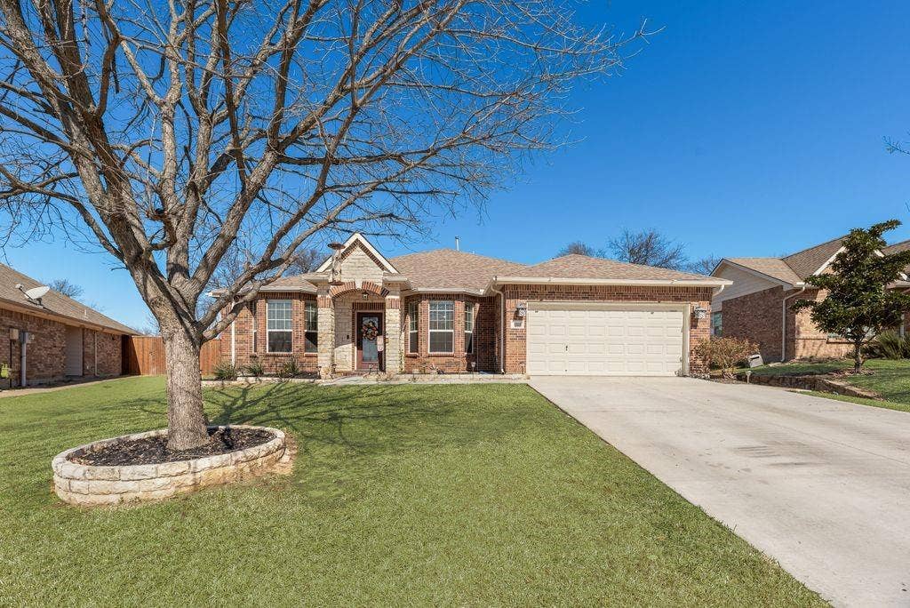 1323 Canyon Creek Road, Wylie, TX 75098 Brick exterior with stone accents, covered entry, attached garage, and concrete driveway
