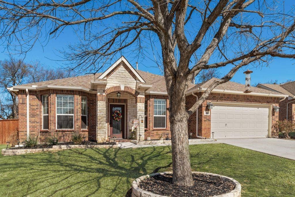 1323 Canyon Creek Road, Wylie, TX 75098 Brick exterior with stone accents, covered entry, bay windows, and an attached two-car garage