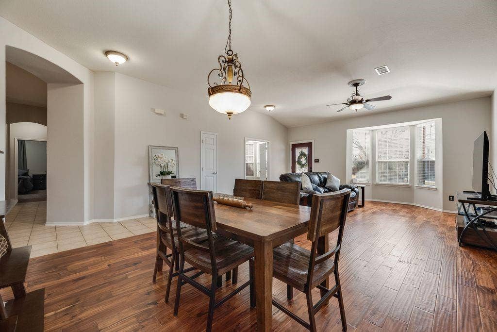 1323 Canyon Creek Road, Wylie, TX 75098 Open-concept living area with wood-finish flooring, a decorative chandelier, and a ceiling fan