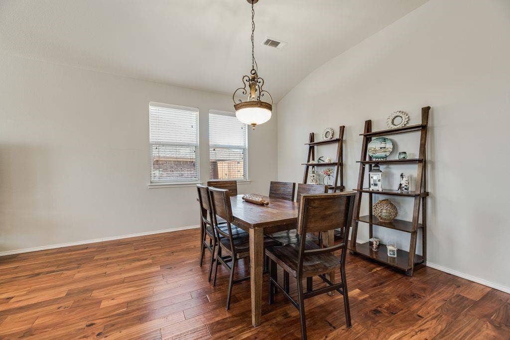 1323 Canyon Creek Road, Wylie, TX 75098 Vaulted ceiling with a decorative chandelier, dual windows with blinds, and wood-finish flooring