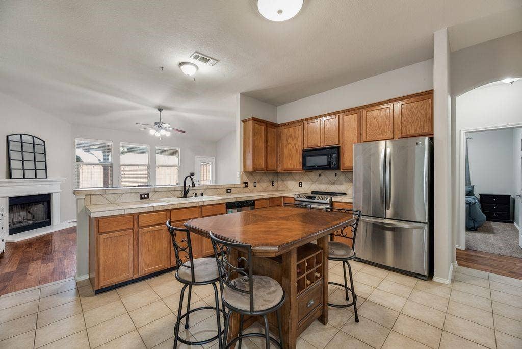 1323 Canyon Creek Road, Wylie, TX 75098 Kitchen featuring wood cabinetry, stainless steel appliances, and a tiled backsplash
