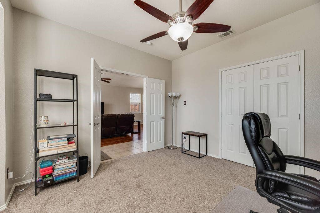 1323 Canyon Creek Road, Wylie, TX 75098 Neutral wall paint, carpet flooring, a ceiling fan with integrated lighting, and a double-door closet