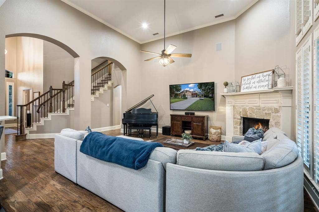 Vaulted ceilings, wood-finish flooring, stone-clad fireplace, and arched doorways