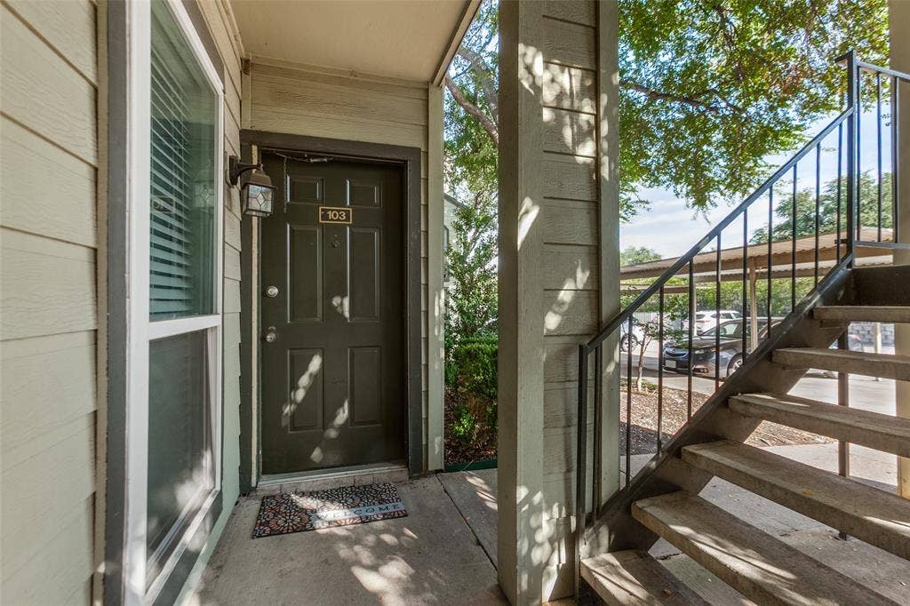 5981 Arapaho Road, #103, Dallas, TX 75248 Entryway featuring a panel door, an exterior wall sconce, and a window with blinds