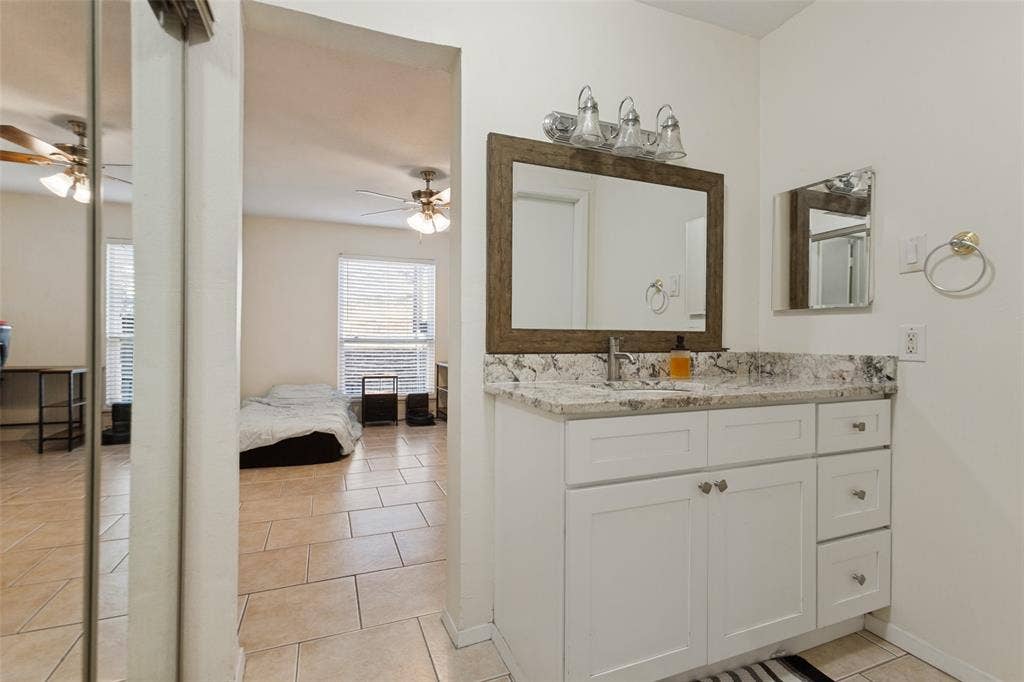 5981 Arapaho Road, #103, Dallas, TX 75248 White shaker-style vanity with a stone countertop and an undermount sink