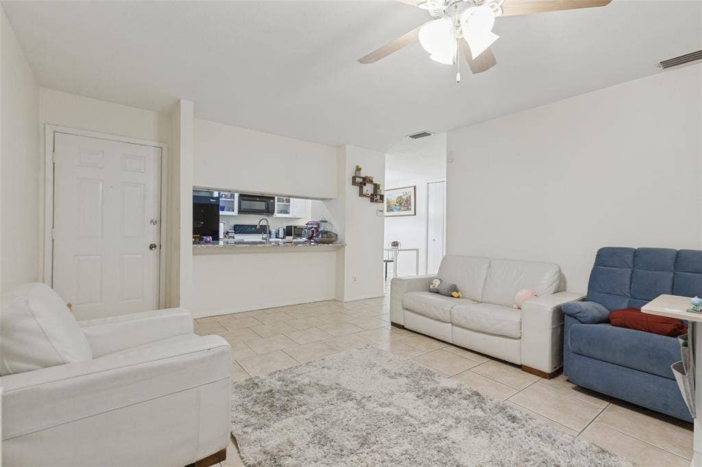 5981 Arapaho Road, #103, Dallas, TX 75248 Recessed kitchen opening with a built-in breakfast bar, tile flooring, and a ceiling fan with integrated lighting