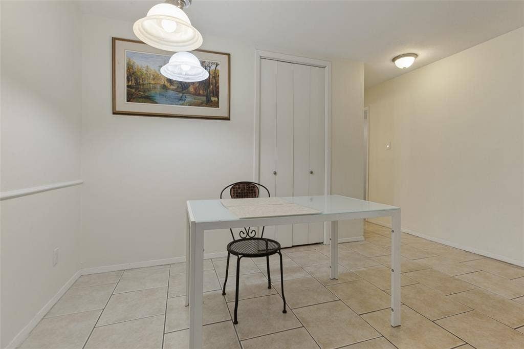 5981 Arapaho Road, #103, Dallas, TX 75248 Tiled flooring, white walls, and a built-in closet with bi-fold doors
