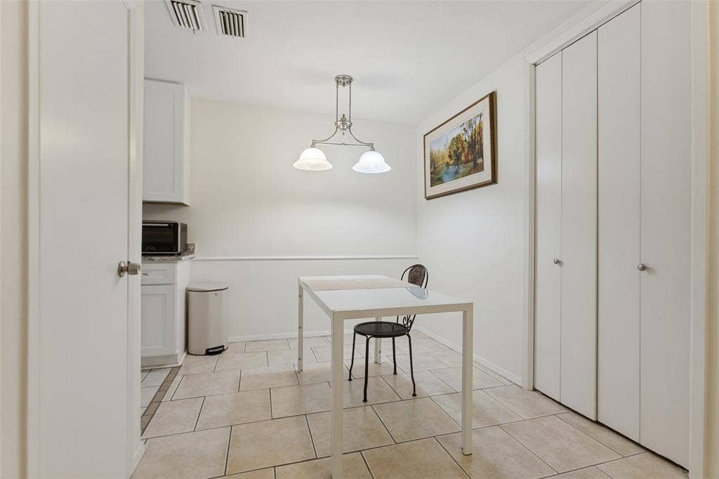 5981 Arapaho Road, #103, Dallas, TX 75248 White cabinetry with a microwave, tile flooring, and a semi-flush mount light fixture