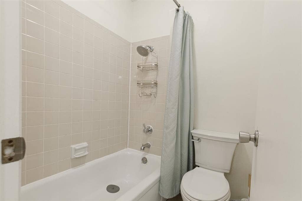 5981 Arapaho Road, #103, Dallas, TX 75248 Bathroom featuring a shower/tub combination, tiled shower surround, and a toilet