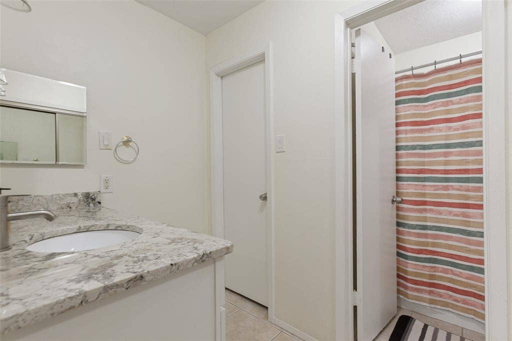 5981 Arapaho Road, #103, Dallas, TX 75248 White vanity with a white countertop and integrated sink