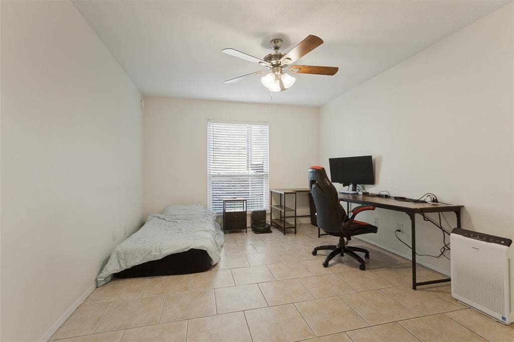 5981 Arapaho Road, #103, Dallas, TX 75248 Neutral-toned tile flooring, white walls, a window with blinds, and a ceiling fan with light fixture