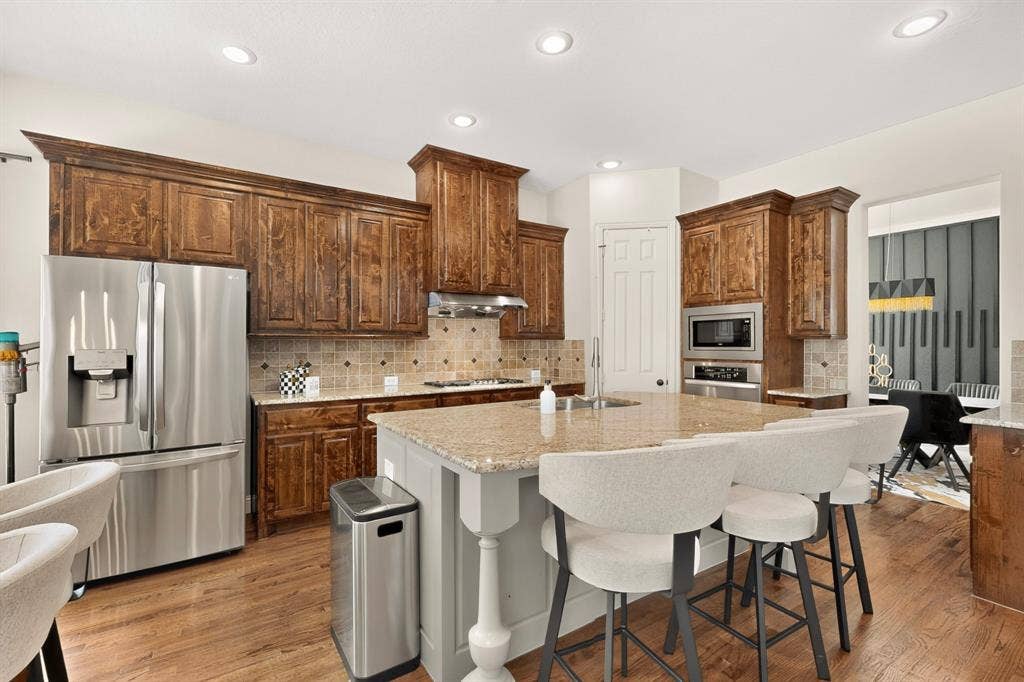 1494 Willingham Drive, Allen, TX 75013 Spacious kitchen featuring wood-finish flooring, recessed lighting, and a kitchen island with stone countertop