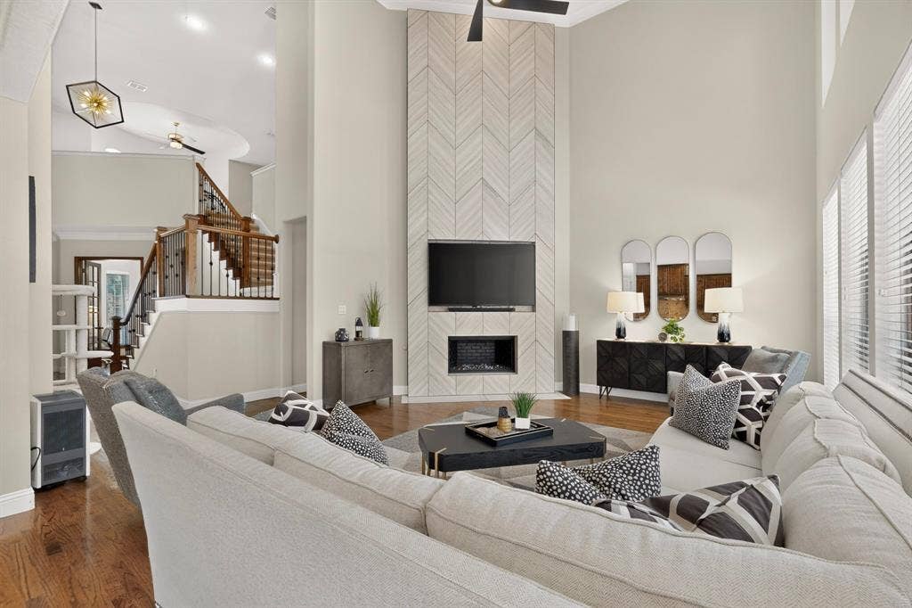 1494 Willingham Drive, Allen, TX 75013 Two-story living area with a chevron-patterned fireplace surround, built-in electric fireplace, and a light-toned ceiling fan
