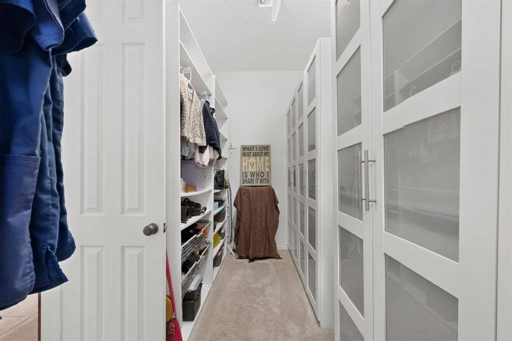 1494 Willingham Drive, Allen, TX 75013 Built-in closet system with open shelving, hanging racks, and white framed doors with frosted glass panels