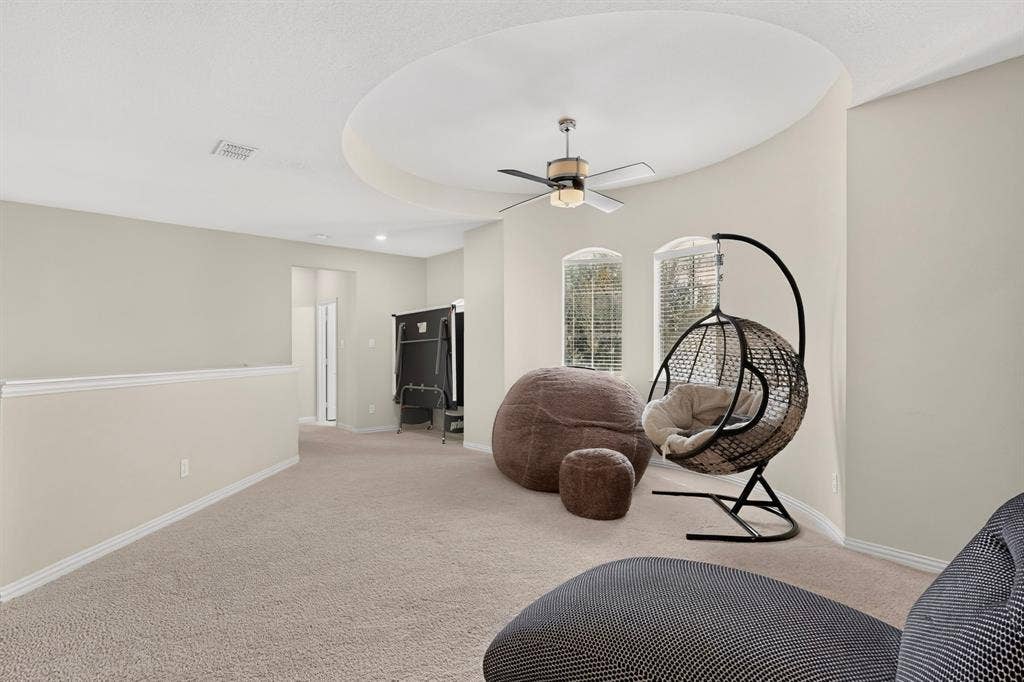 1494 Willingham Drive, Allen, TX 75013 Carpeted room featuring a circular tray ceiling, ceiling fan, and two arched windows