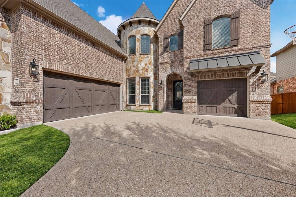 1494 Willingham Drive, Allen, TX 75013 Brick and stone exterior featuring multiple garages, a turret, and decorative window shutters