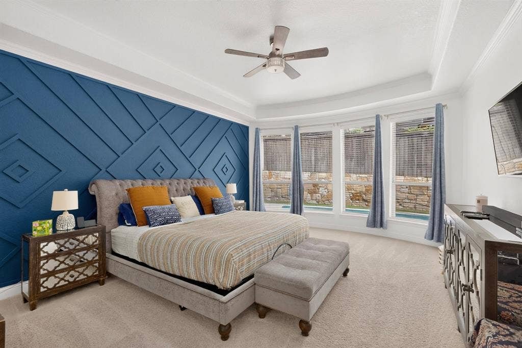 1494 Willingham Drive, Allen, TX 75013 Accent wall with geometric paneling, tray ceiling, ceiling fan, and curved window wall