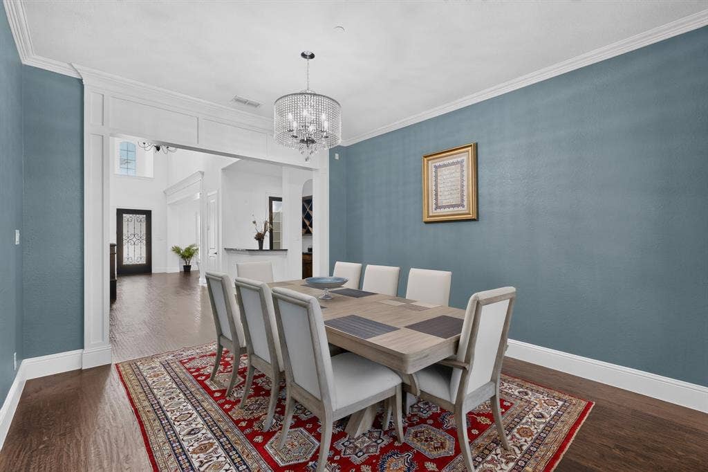 13853 Myatt Avenue, Frisco, TX 75035 Spacious dining area featuring wood-finish flooring, a decorative chandelier, crown molding, and an arched entry