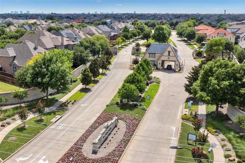 13853 Myatt Avenue, Frisco, TX 75035 Gated community entrance featuring stone and timber-frame architecture, lush landscaping, and a manicured streetscape