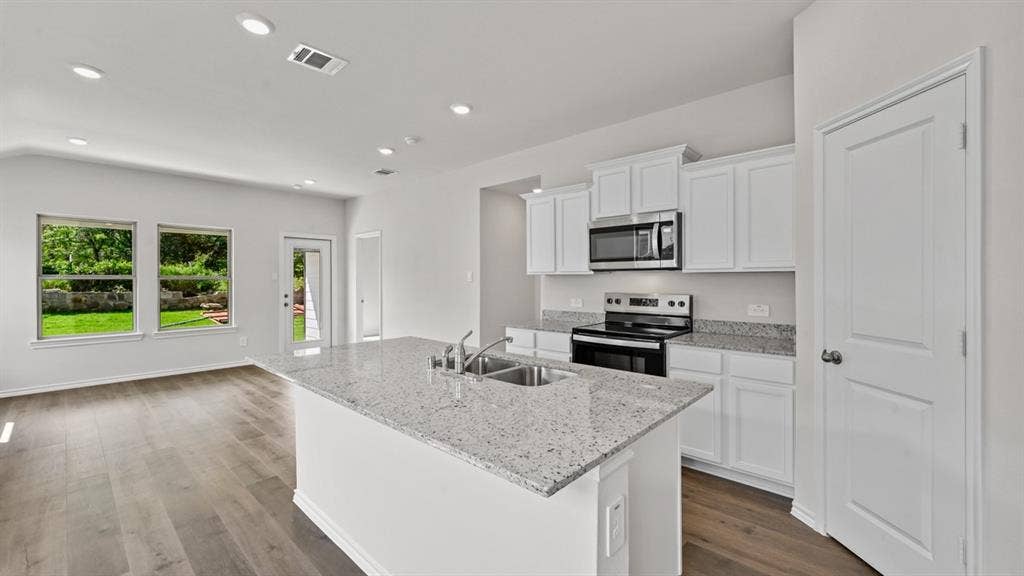 1667 Blaire Drive, Tyler, TX 75702 Modern kitchen featuring a central island with an undermount dual-basin sink and a speckled countertop