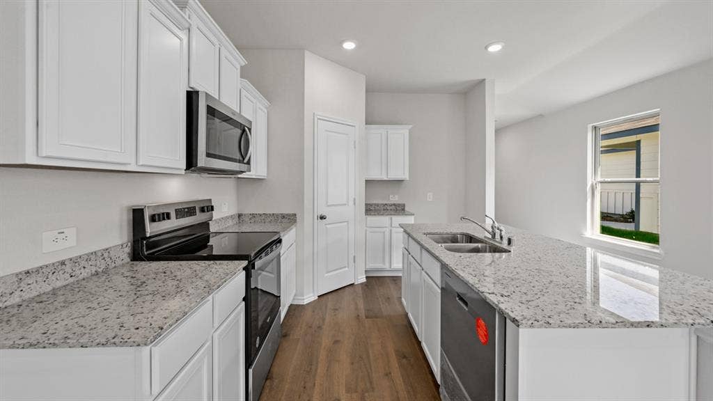 1667 Blaire Drive, Tyler, TX 75702 Contemporary kitchen featuring white cabinetry, light-toned countertops, stainless steel appliances, and wood-finish flooring