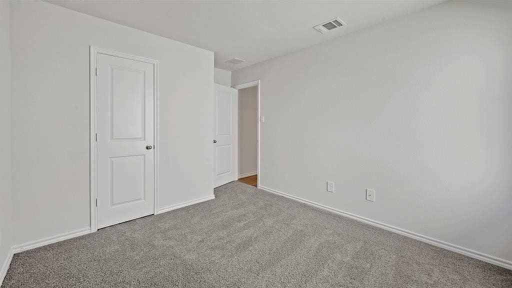 1667 Blaire Drive, Tyler, TX 75702 Neutral-toned room featuring grey textured carpeting and white baseboards