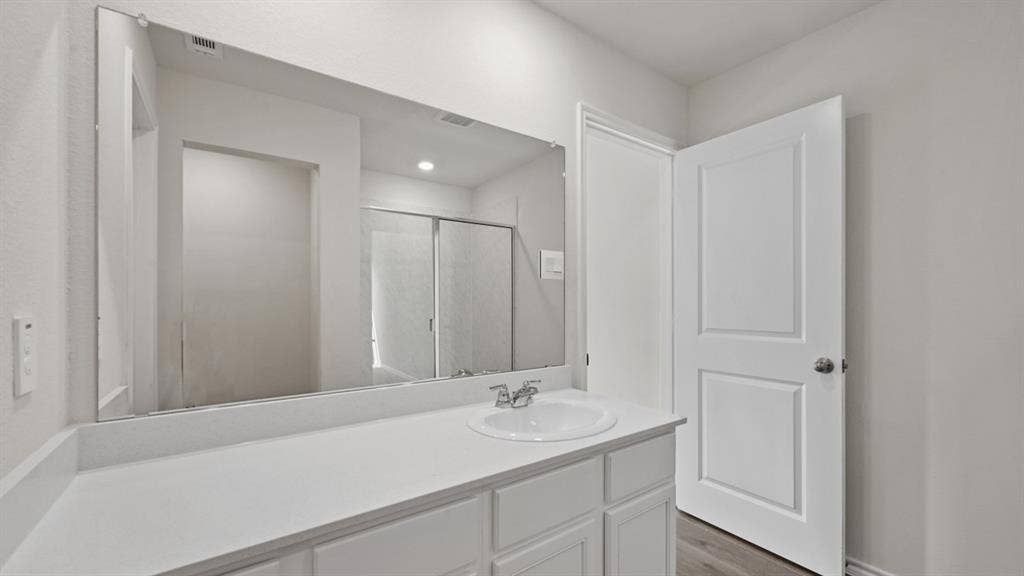 1667 Blaire Drive, Tyler, TX 75702 White vanity with a built-in sink, chrome faucet, and expansive wall-mounted mirror