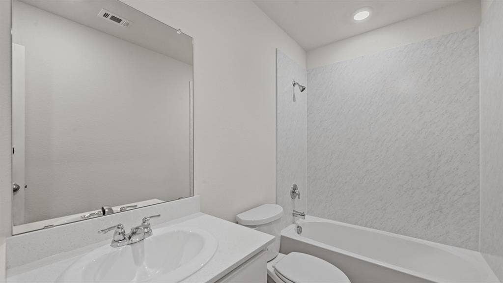 1667 Blaire Drive, Tyler, TX 75702 Bathroom featuring a white vanity with an integrated sink, chrome faucet, and a large wall-mounted mirror