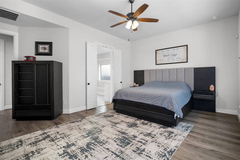 Wood-finish flooring, ceiling fan with integrated lighting, and light gray wall paint