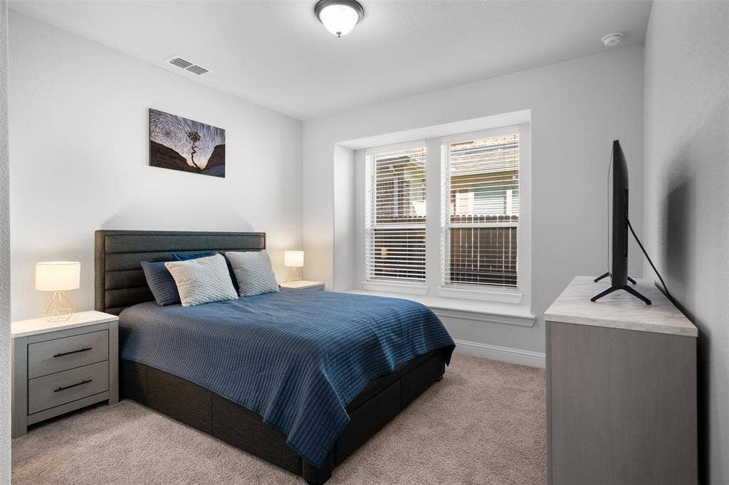 Carpeted flooring, window with blinds, flush mount ceiling light, and light gray wall paint