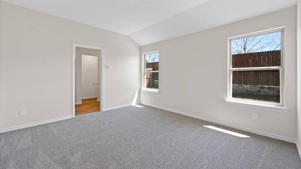 1675 Blaire Drive, Tyler, TX 75702 Spacious room featuring vaulted ceilings, light gray wall paint, and plush gray carpeting