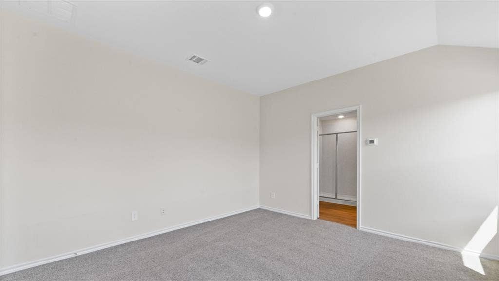 1675 Blaire Drive, Tyler, TX 75702 Spacious room featuring vaulted ceilings, neutral-toned walls, and plush grey carpeting